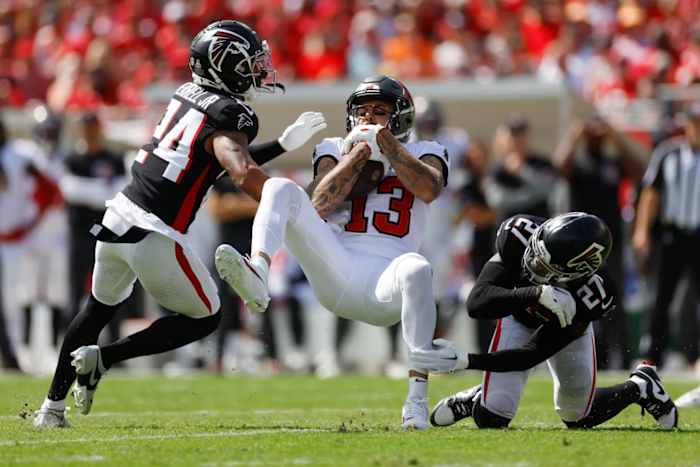 Buccaneers WR Mike Evans hauls in a catch between two Falcons defenders.